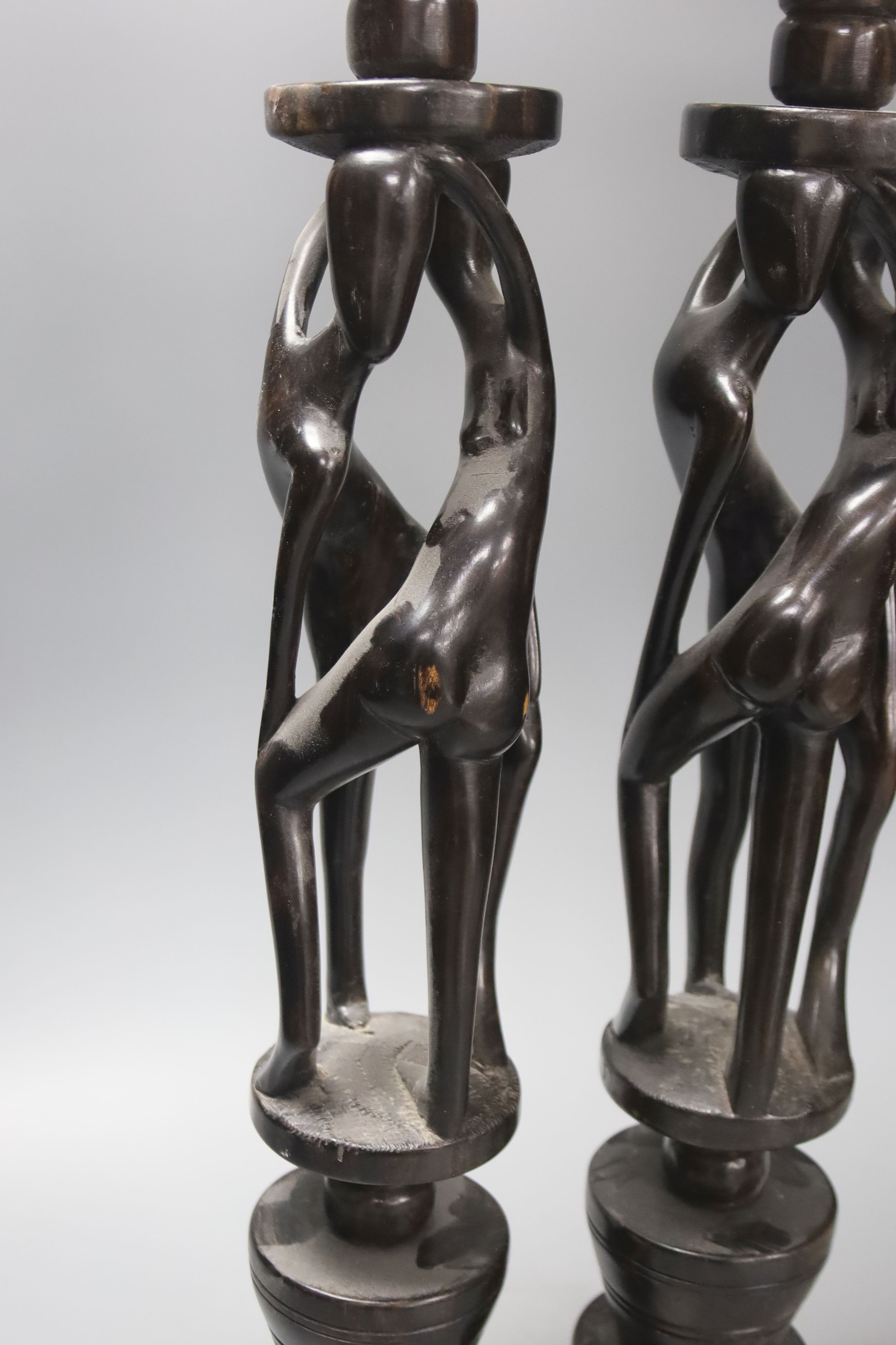 A pair of African tribal figural ebony candlestands, 60cm